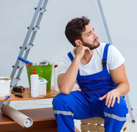 Repairman doing renovation repair in the house with paper wallpaの写真素材