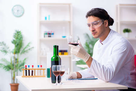 Male chemist examining wine samples at labの写真素材