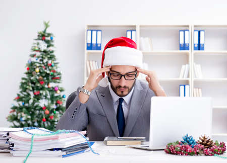 Young businessman celebrating christmas in the officeの写真素材