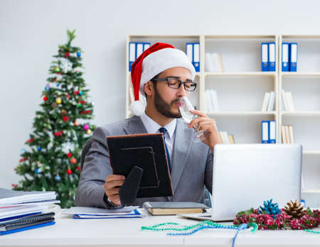 Young businessman celebrating christmas in the officeの写真素材