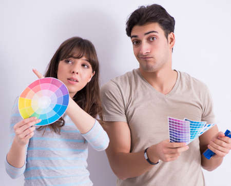 The young family doing renovation at home - painting walls
