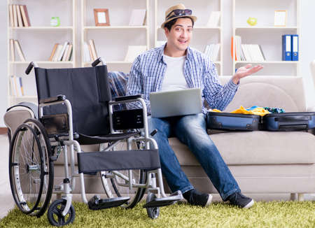 Disabled man booking travel online using laptop computerの写真素材
