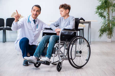 Young male doctor pediatrist and boy in wheel-chairの写真素材