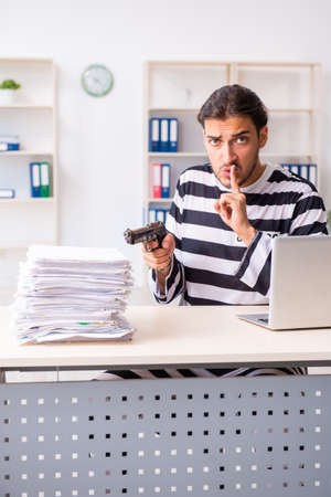 Young employee feeling like prisoner at workの写真素材