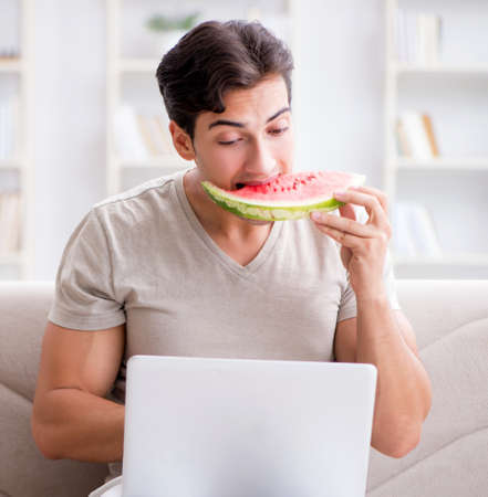 Man eating watermelon at homeの写真素材