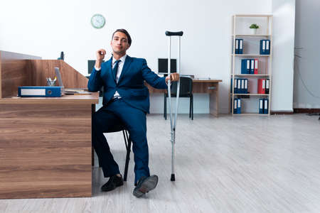 Young leg injured employee in the officeの写真素材