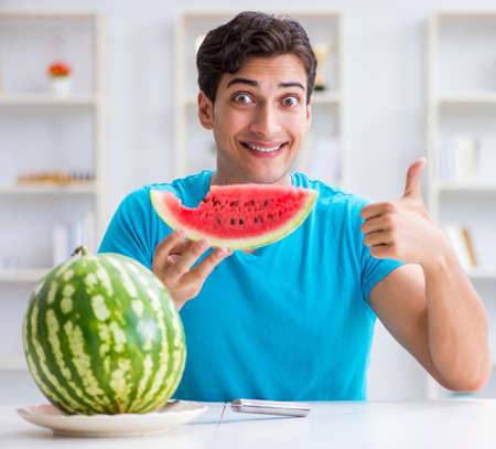 Man eating watermelon at homeの写真素材