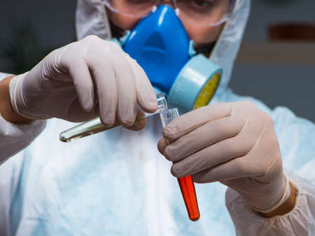 The young make scientist working with dangerous hazardous substances