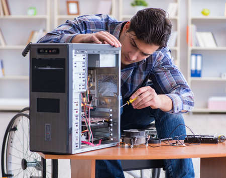 The disabled man on wheelchair repairing computerの写真素材