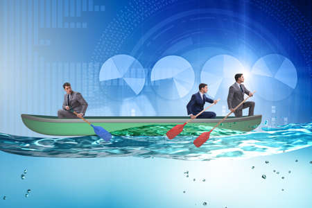 Disagreement concept with businessmen rowing in different directionsの写真素材