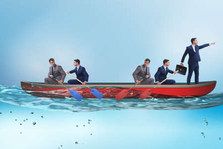 Disagreement concept with businessmen rowing in different directionsの写真素材