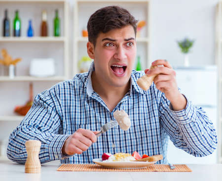 Man eating tasteless food at home for lunchの写真素材