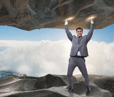 Businessman supporting stone under pressure