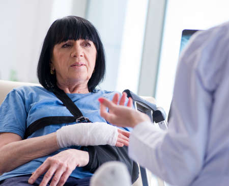 Doctor examining old mature woman after incidentの写真素材