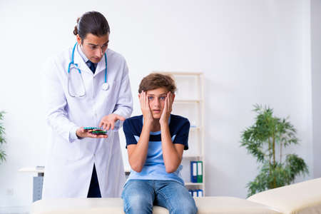 Young male doctor examining boy in the clinic