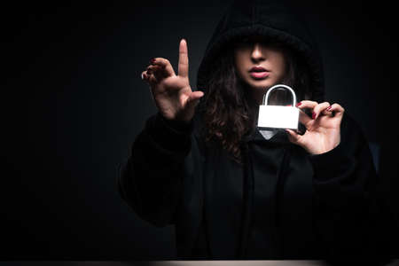 Female hacker hacking security firewall late in officeの写真素材
