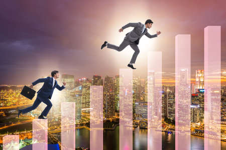 Businessman climbing bar charts in growth concept