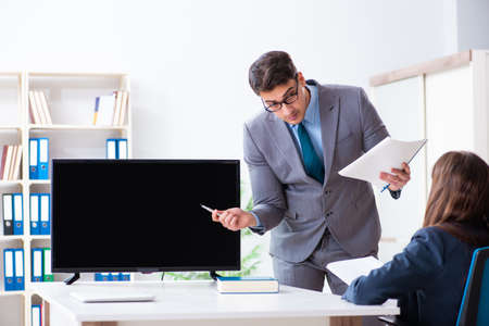 Young employee making presentation to his female bossの写真素材