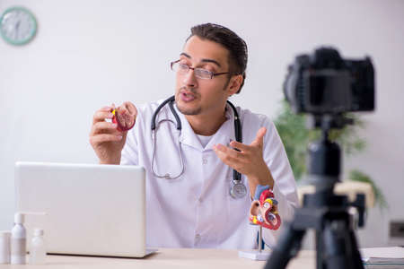 Young male doctor cardiologist recording video for his blog