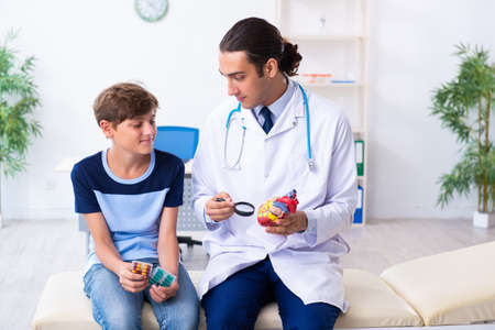 Young male doctor examining boy in the clinicの写真素材