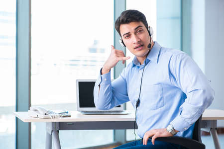 Male call-center operator in business concept