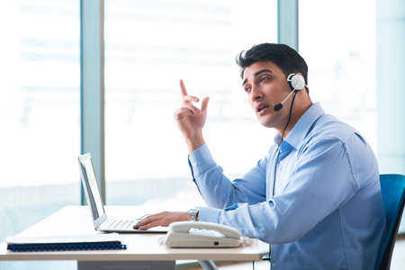 Male call-center operator in business conceptの写真素材