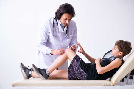 Boy tennis player visiting young doctor traumatologistの写真素材