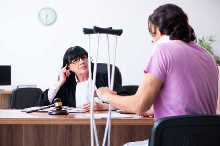 Disabled man consulting judge for damages litigationの写真素材