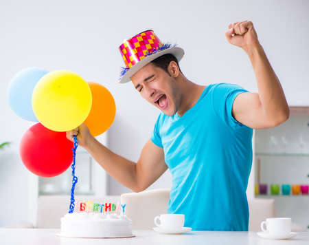 Young man celebrating birthday alone at homeの写真素材
