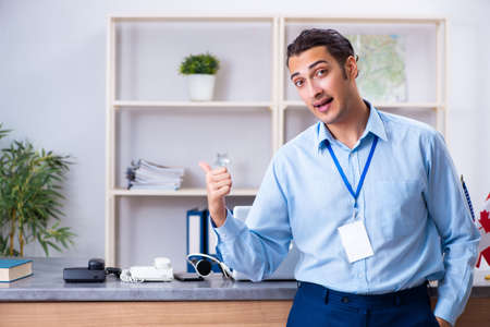 Young male travel agent working in the officeの写真素材
