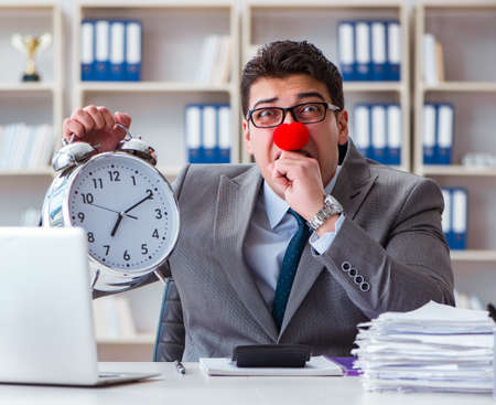 Clown businessman with alarm clock missing dieadlineの写真素材