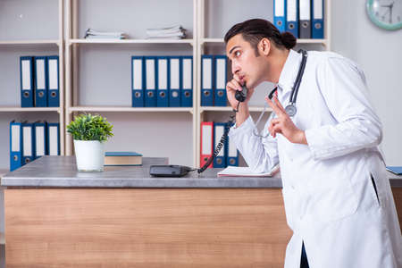 Young male doctor at the reception in the hospitalの写真素材