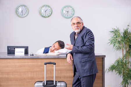 Old businessman at the hotel receptionの写真素材