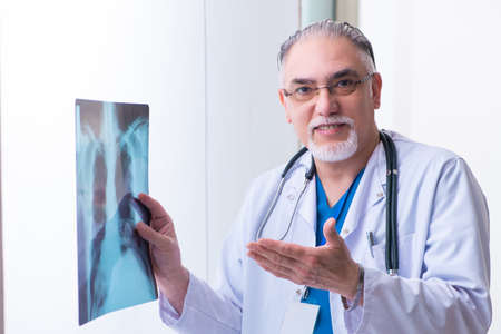 Old male doctor working in the clinicの写真素材