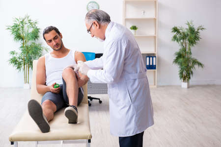 Young male patient visiting experienced doctorの写真素材