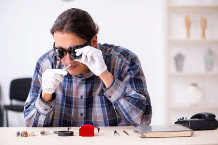 The young male jeweler at workshop