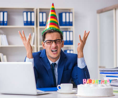 Man celebrating birthday in the officeの写真素材