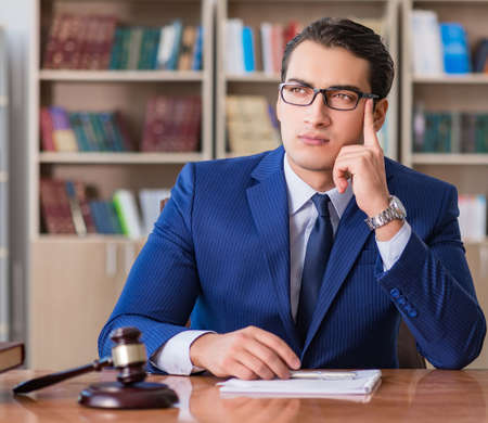 Handsome judge with gavel sitting in courtroomの写真素材