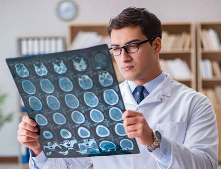Young doctor looking at computed tomography x-ray imageの写真素材