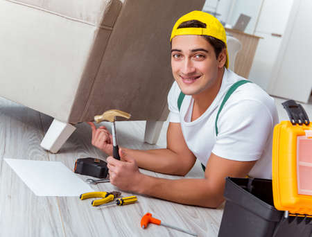 Worker repairing furniture at homeの写真素材