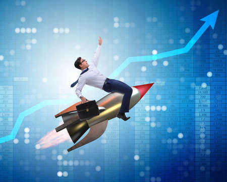 Businessman flying on rocket in business conceptの写真素材