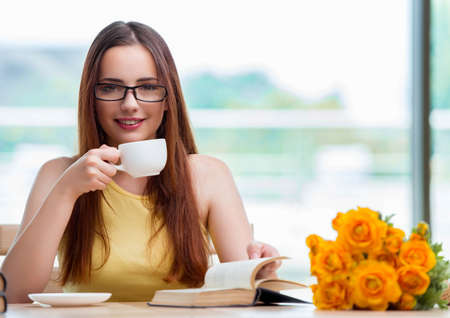 Young student drinking coffee while sudyingの写真素材