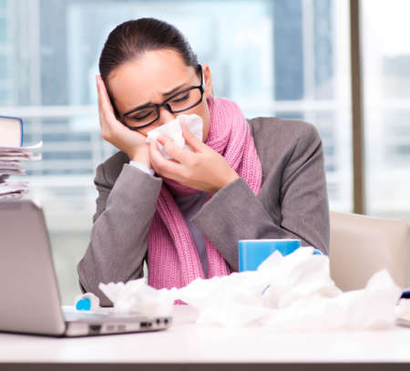 The young businesswoman sick in the officeの写真素材