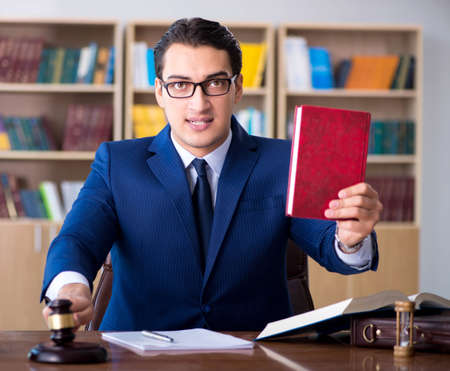 Handsome judge with gavel sitting in courtroom