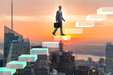 Businessman climbing bar charts in growth conceptの写真素材