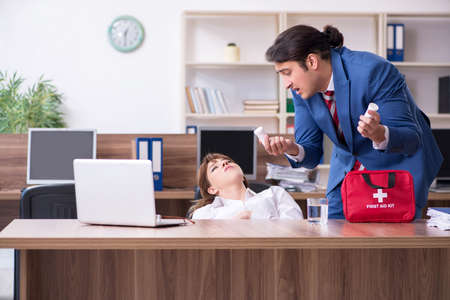 Young employee suffering in the officeの写真素材