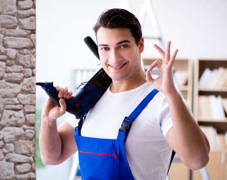 Repairman working with drilling drill perforatorの写真素材