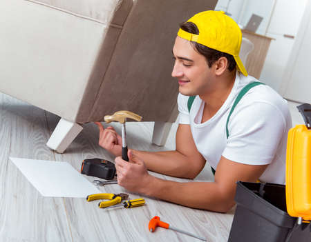 Worker repairing furniture at homeの写真素材