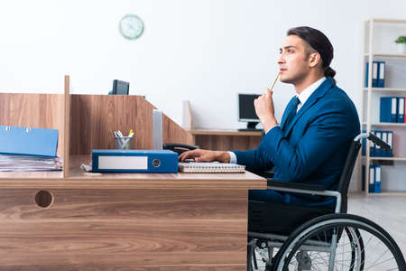 Young male employee in wheel-chairの写真素材