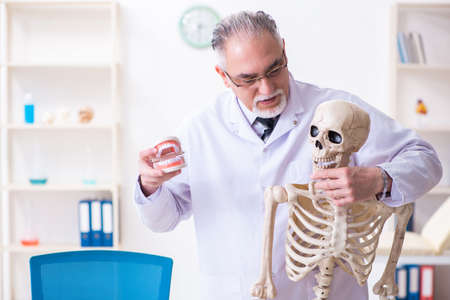 Aged male doctor with skeletonの写真素材